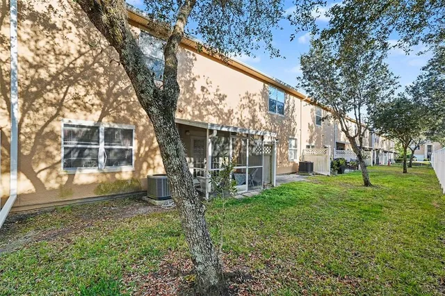 a view of backyard with large trees and plants