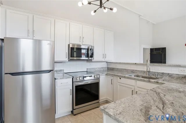 a kitchen with stainless steel appliances granite countertop a stove a refrigerator and a sink