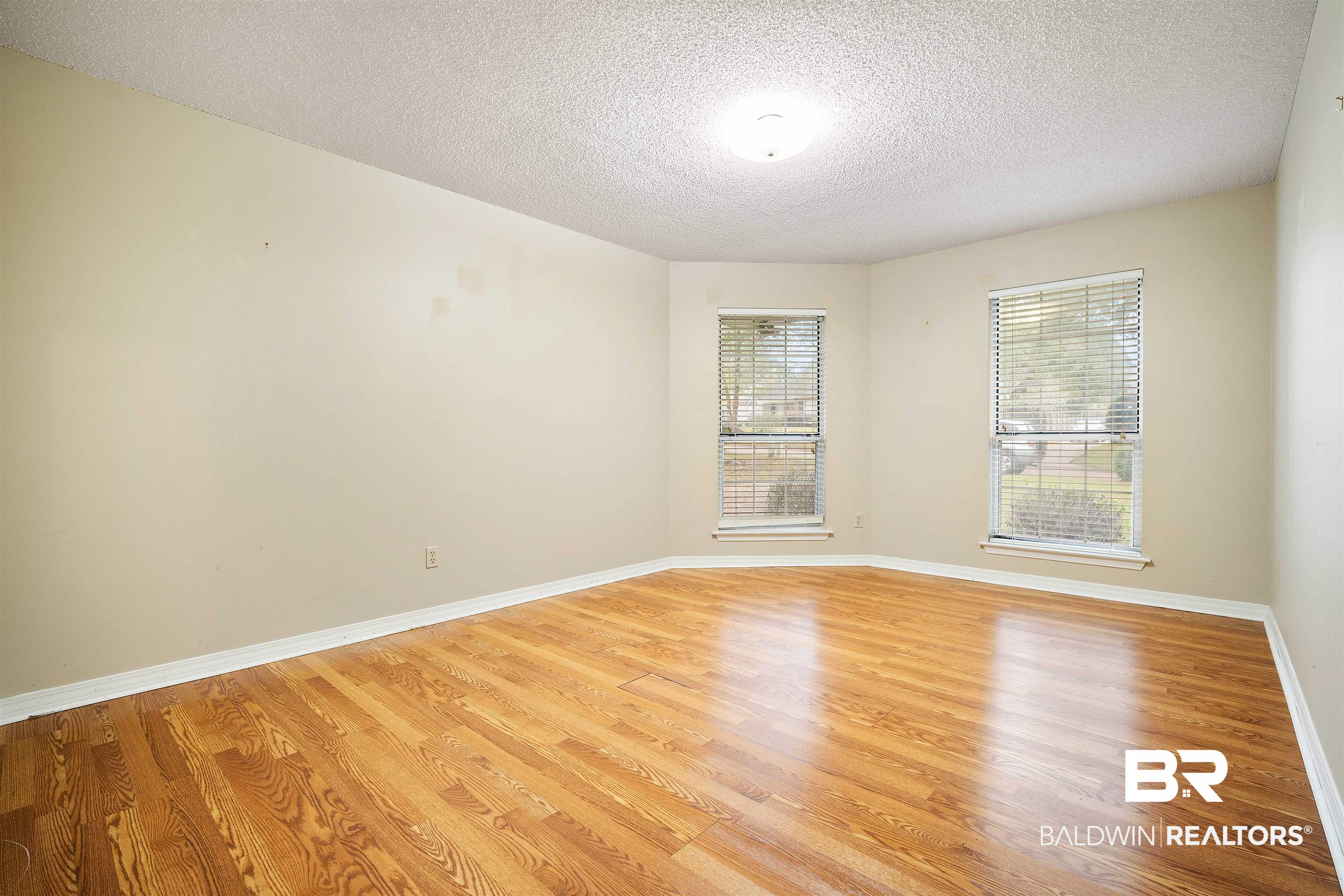 7100 Huntington Court South Mobile, AL 36619 - Photo 21 of 30 Empty room featuring light wood-type flooring and a textured ceiling