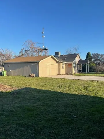 a view of a big house with a big yard and potted plants