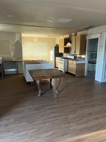 a room with wooden floor table and chairs