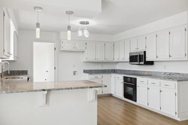 a kitchen with cabinets appliances and a counter space