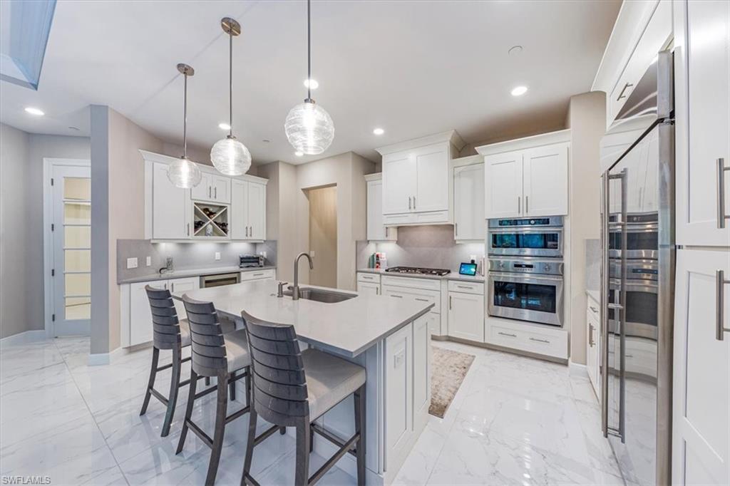 a kitchen with stainless steel appliances a stove a refrigerator and a kitchen island