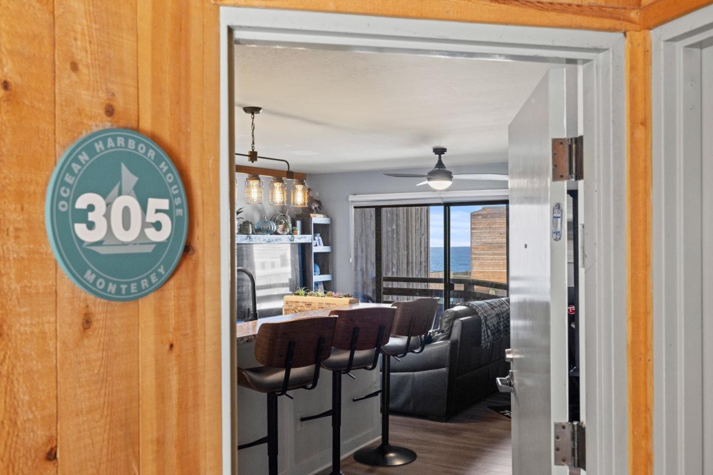 125 Surf Way, Unit 305 Monterey, CA 93940 - Photo 4 of 27 a dining room with furniture and a chandelier