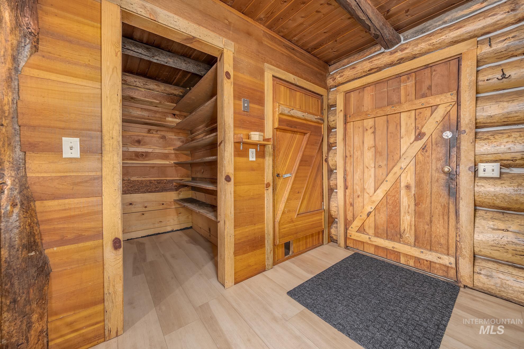 2150 Seid Creek Road Cambridge, ID 83610 - Photo 6 of 50 Rustic interior featuring log walls, wood-finish flooring, and a barn door style entry