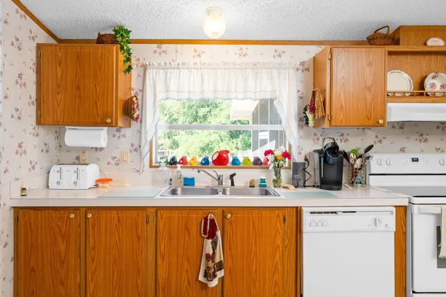a kitchen with a sink a stove and a window