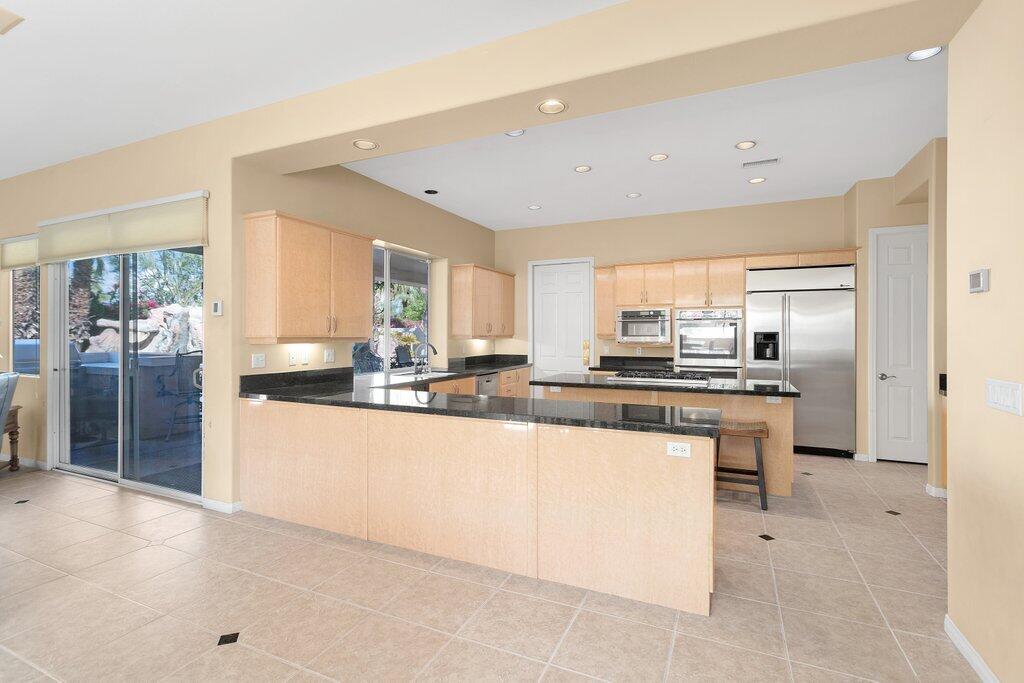 8 MacBeth Court Rancho Mirage, CA 92270 - Photo 10 of 46 a kitchen with stainless steel appliances granite countertop a sink and cabinets