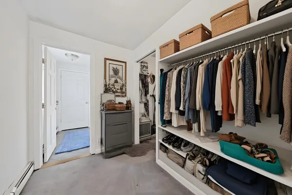 a view of walk in closet with clothes and shoes