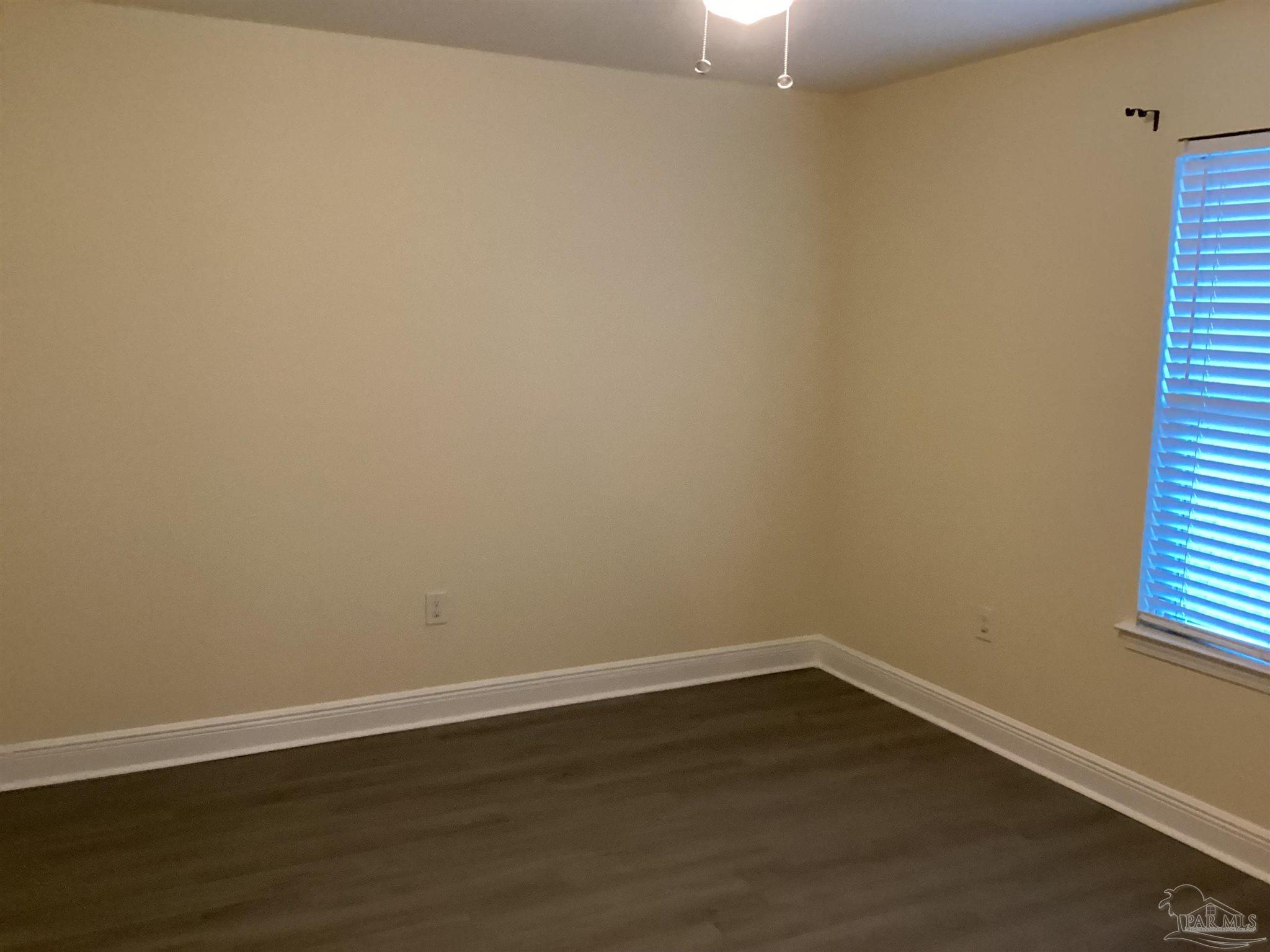 196 Millet Circle Cantonment, FL 32533 - Photo 18 of 20 a view of an empty room with wooden floor and a window