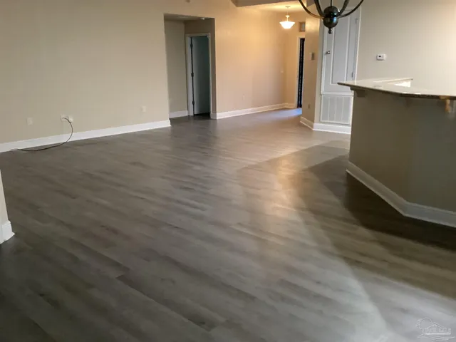 an empty room with wooden floor and cabinet