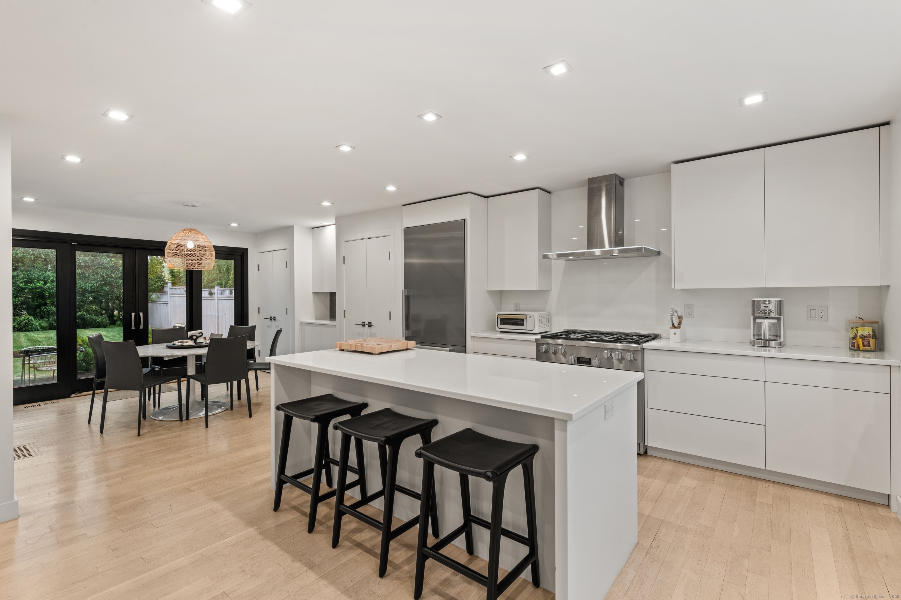 200 Hillspoint Road Westport, CT 06880 - Photo 13 of 37 an open kitchen with kitchen island a stove a sink a dining table and chairs