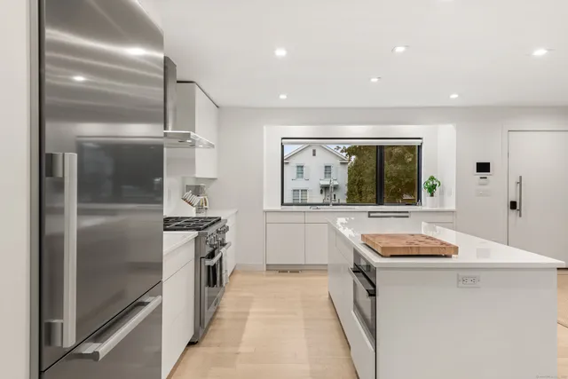 a kitchen with stainless steel appliances granite countertop a stove a sink and a refrigerator