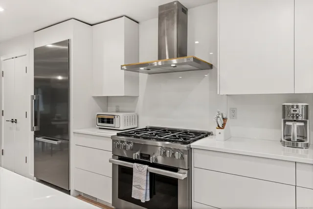 a kitchen with stainless steel appliances a sink stove and refrigerator