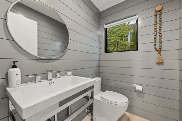 a bathroom with a sink a toilet and a mirror