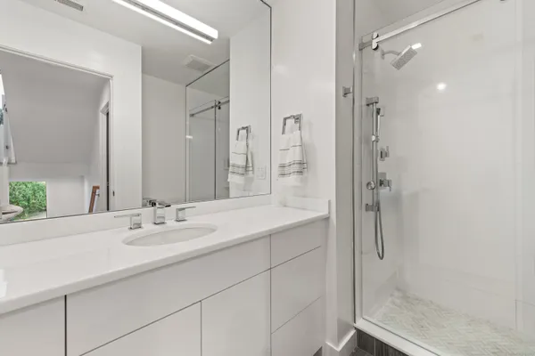 a bathroom with a shower sink and mirror