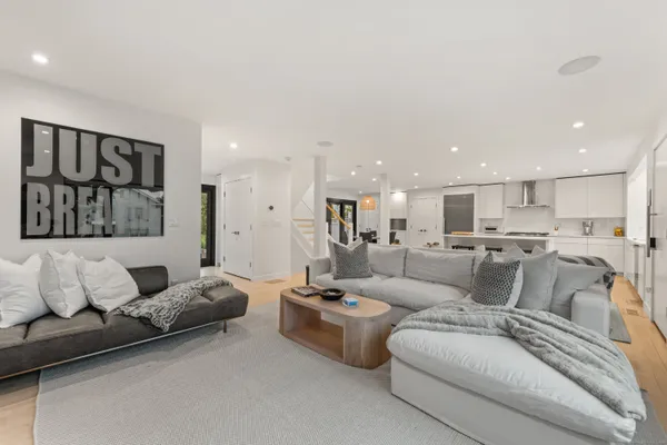 a living room with furniture and a view of kitchen