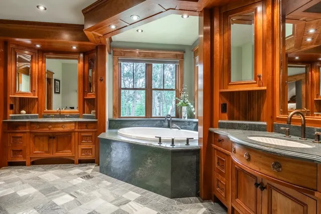 a bathroom with a tub sink and mirror