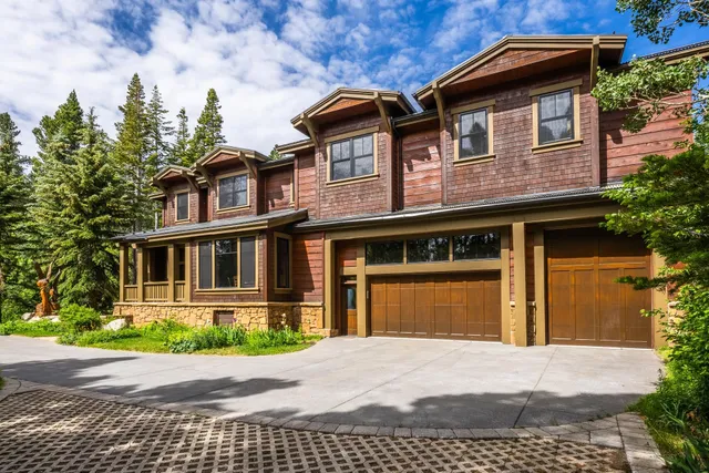 a front view of a house with a yard and potted plants