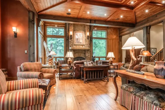 a living room with furniture a large window and a chandelier