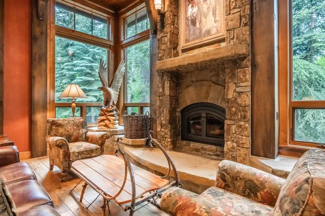 a living room with furniture a fireplace and a floor to ceiling window
