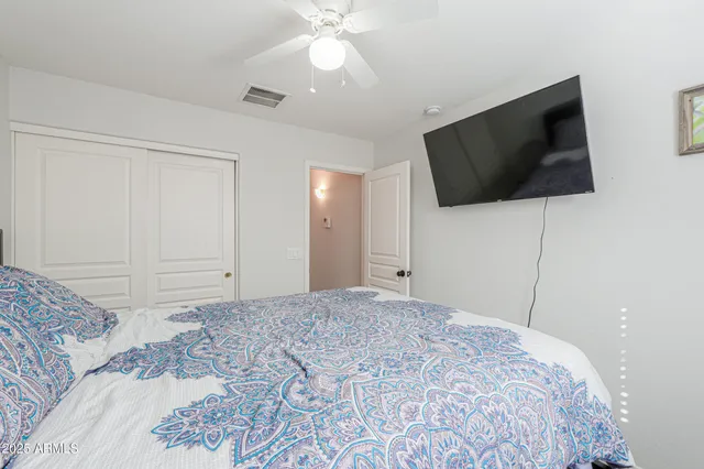 a bedroom with a large bed and a flat screen tv