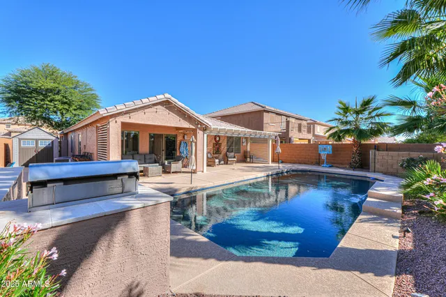 a view of house with swimming pool and sitting area