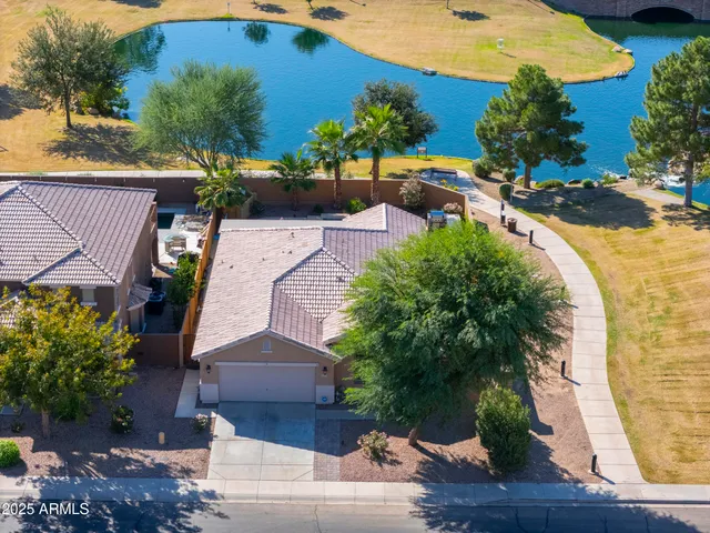 an aerial view of a house with a yard and lake view