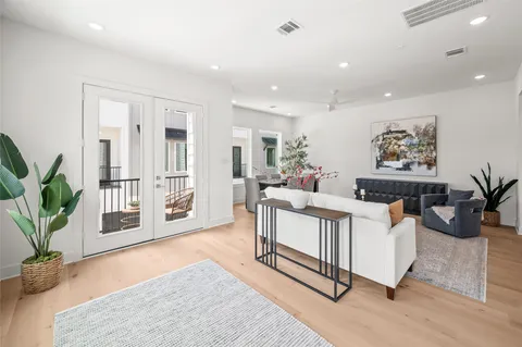 a living room with furniture a potted plant and kitchen view