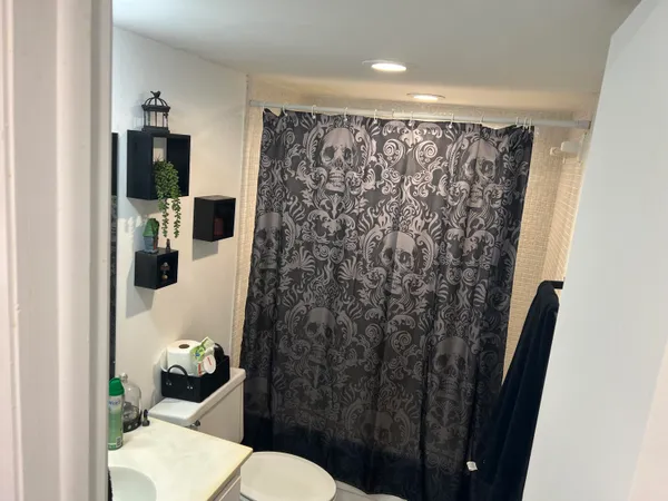 a bathroom with a toilet and a shower curtain