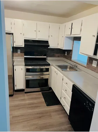 a kitchen with granite countertop white cabinets and appliances