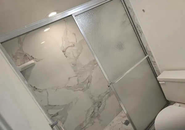 a bathroom with a toilet and a shower