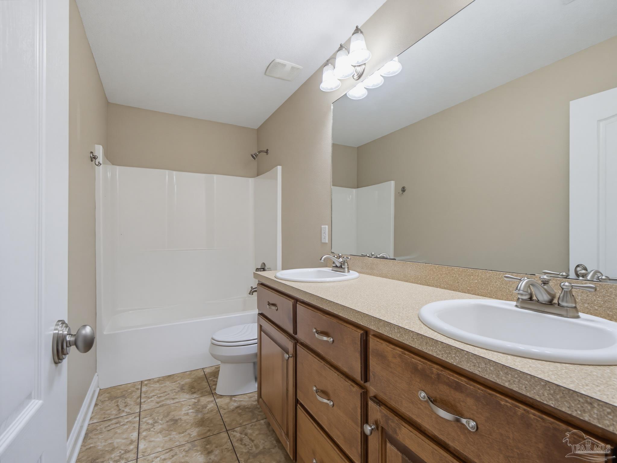 5567 Jones Street Milton, FL 32570 - Photo 37 of 48 a bathroom with a granite countertop sink a toilet a mirror and shower