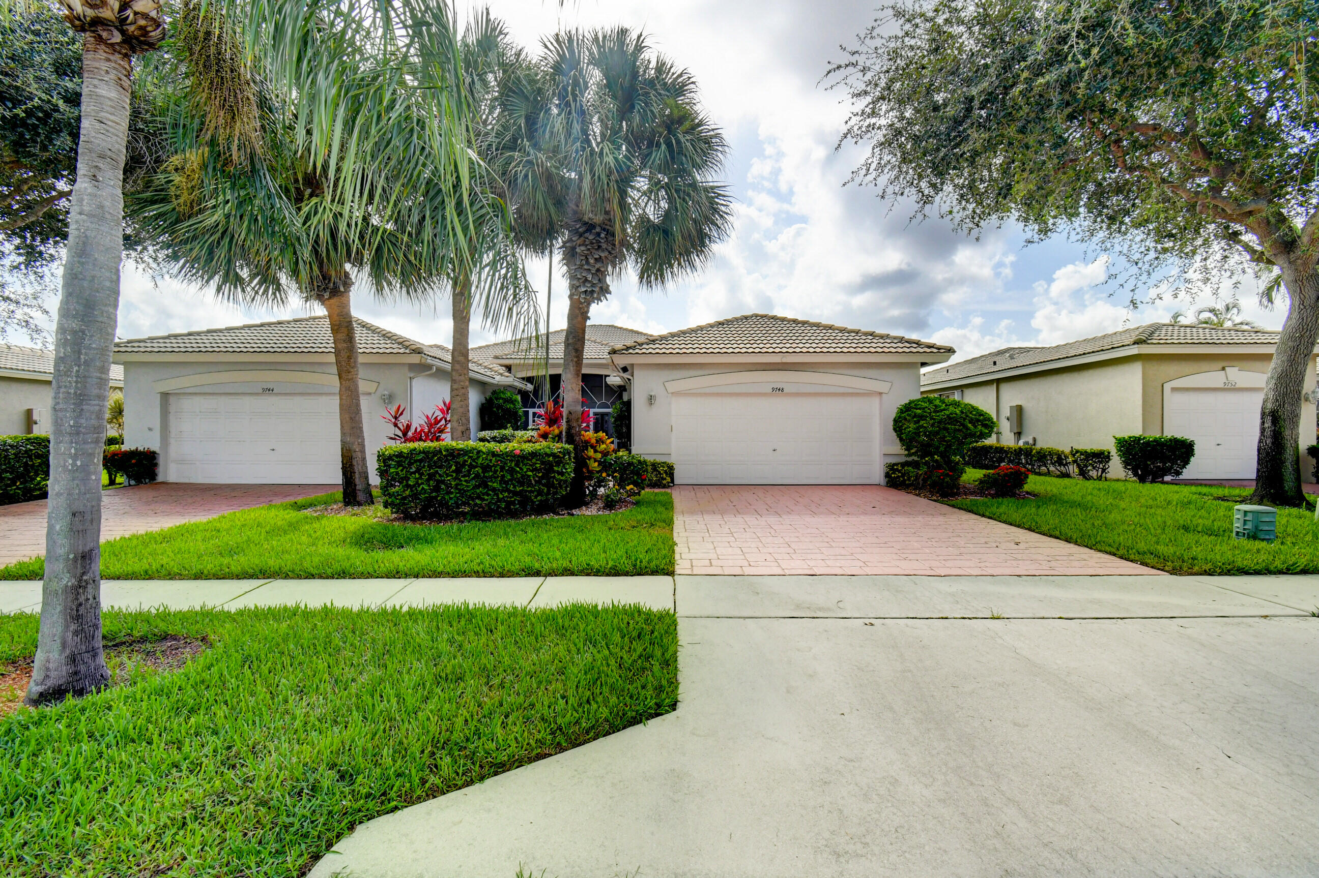 a front view of a house with a garden and yard