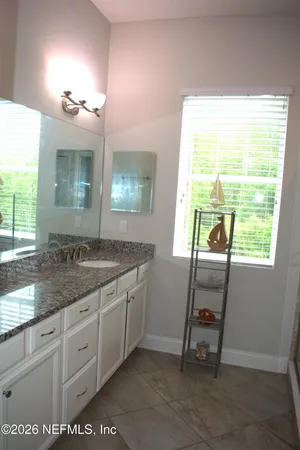a spacious bathroom with a granite countertop sink a toilet and a large mirror