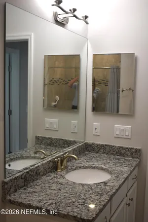 a bathroom with a granite countertop sink and a mirror