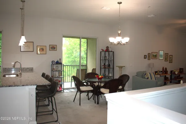 a living room with furniture a chandelier and a large window
