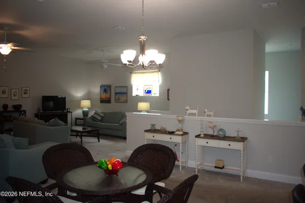 a living room with kitchen island furniture and a chandelier