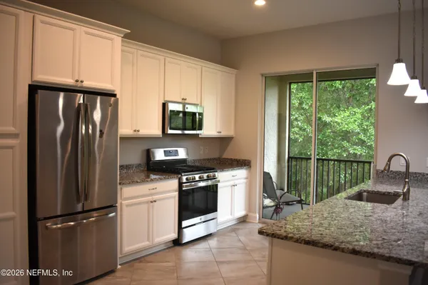 a kitchen with stainless steel appliances granite countertop a refrigerator sink and stove