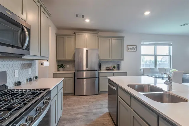 a kitchen with stainless steel appliances granite countertop a sink stove and refrigerator