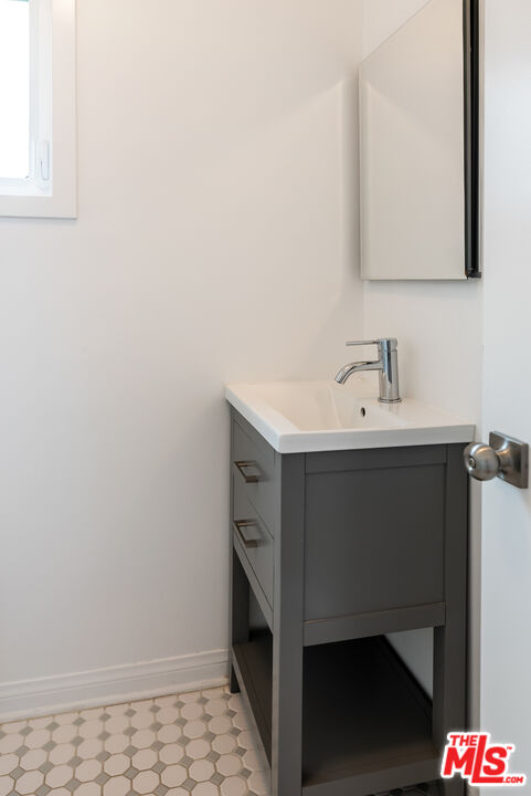 1253 South Rimpau Boulevard Los Angeles, CA 90019 - Photo 57 of 71 a bathroom with a sink and a mirror