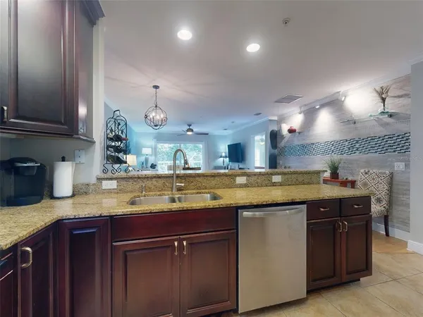 a kitchen with kitchen island granite countertop stainless steel appliances and refrigerator