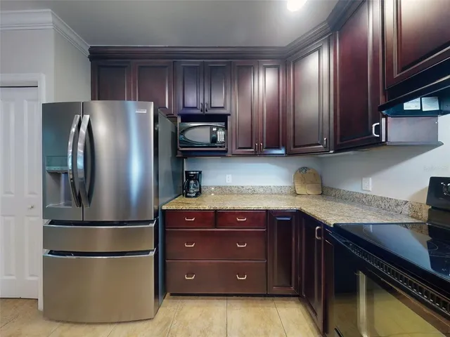 a kitchen with granite countertop stainless steel appliances and wooden cabinets