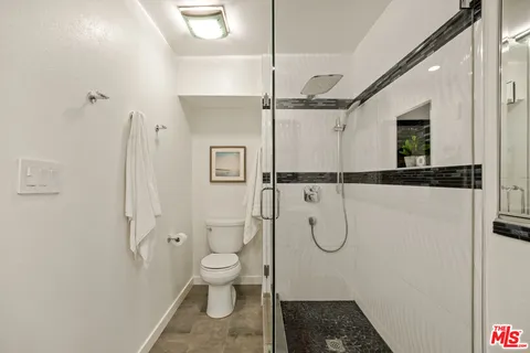 a bathroom with a toilet and a shower
