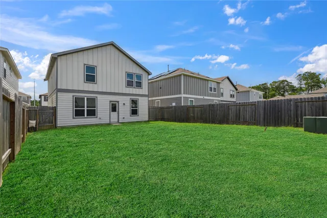 a view of a yard in front of a house with large tree