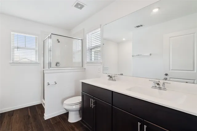 a bathroom with a toilet a sink a mirror and vanity