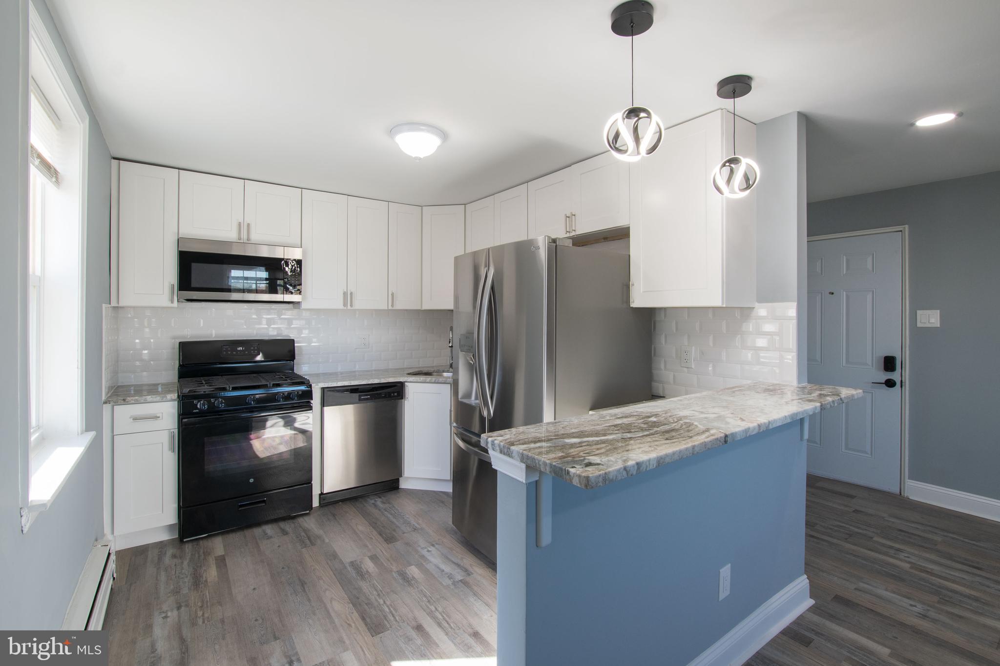 5905 Houghton Street, Unit 2 Philadelphia, PA 19128 - Photo 4 of 14 a kitchen with granite countertop a refrigerator oven a sink and dishwasher