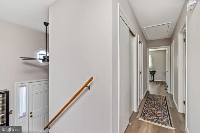 a view of a hallway with wooden floor and staircase