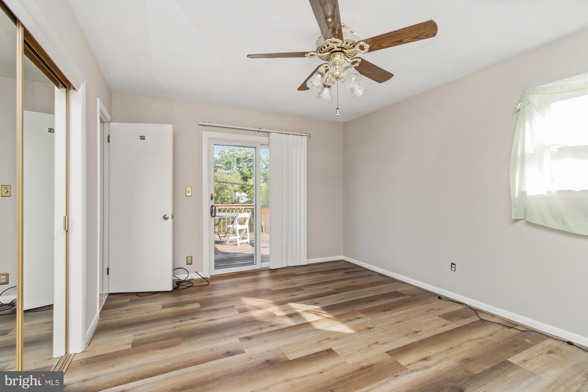 3622 Claires Lane Baltimore, MD 21220 - Photo 29 of 43 an empty room with a chandelier fan and windows