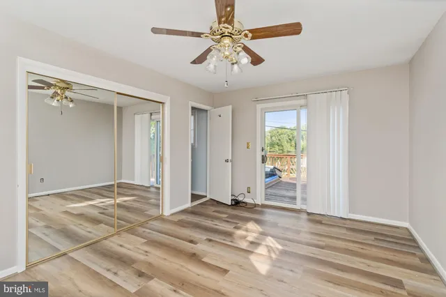 a view of empty room with window and ceiling fan