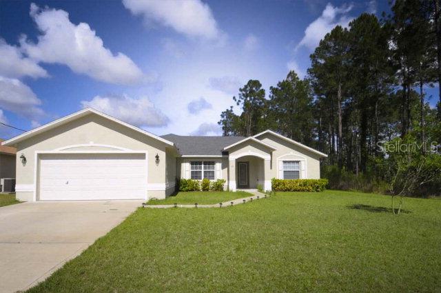 18 Renn Lane Palm Coast, FL 32164 - Photo 1 of 1 a front view of a house with a garden and yard